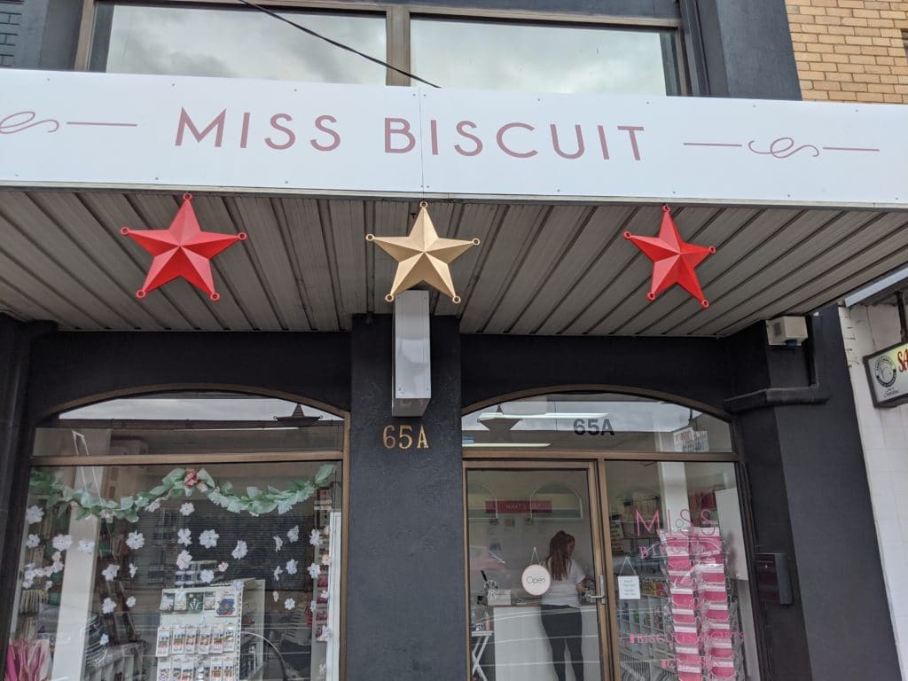 Cable ties used to hang Christmas stars on a sign fascia in front of a shop